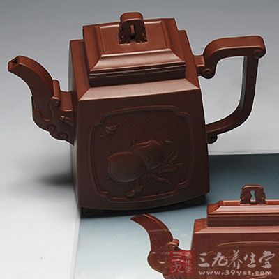 壶体正反面雕塑画屏花纹，正面上堆塑出两粒饱满的寿桃，一只倒飞的蝙蝠