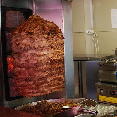 用一根粗大的铁棍将肉一片片地穿起来，做成一个巨大的肉团