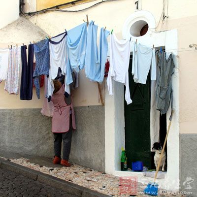 把衣服挂起来，将吹风机定在冷风挡