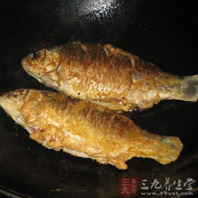 將煎好的魚頭朝外尾朝內(nèi)轉(zhuǎn)圈擺在蔥姜等調(diào)料上，為第一層