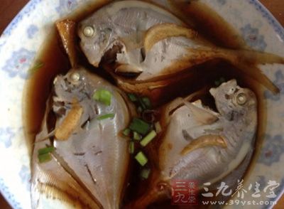 將熱油澆在撒上蔥絲鯧魚上