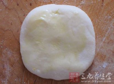 再把小面卷擀成饼胚，在饼的两面刷油