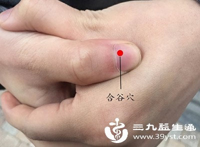 用拇指按压手背“合谷穴”